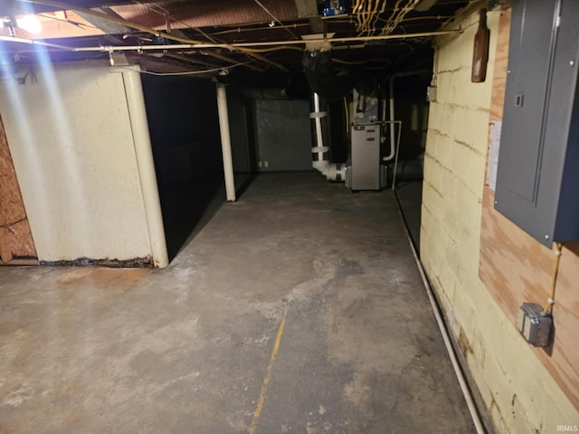 unfinished below grade area featuring electric panel and heating unit