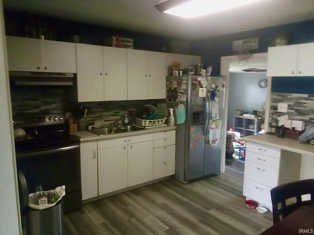 kitchen with light countertops, stainless steel fridge, under cabinet range hood, and range with electric stovetop