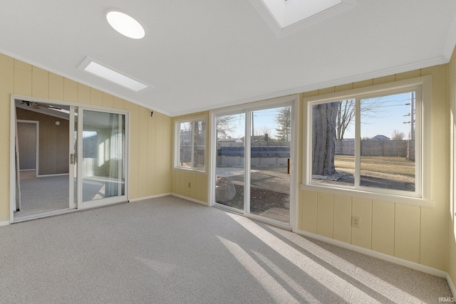 unfurnished sunroom featuring vaulted ceiling with skylight