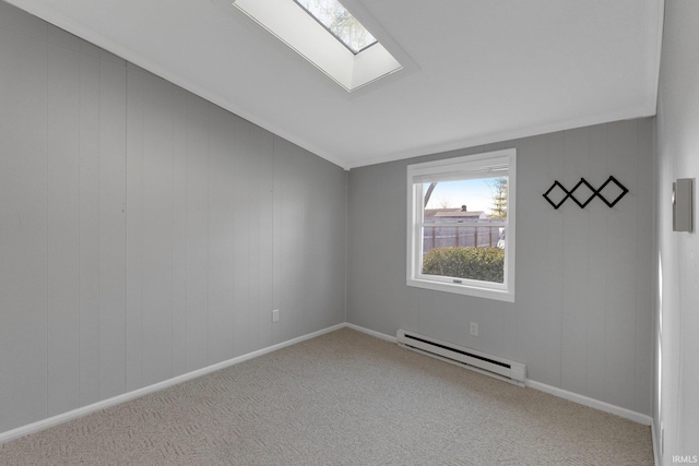 spare room featuring lofted ceiling with skylight, carpet flooring, crown molding, baseboards, and baseboard heating