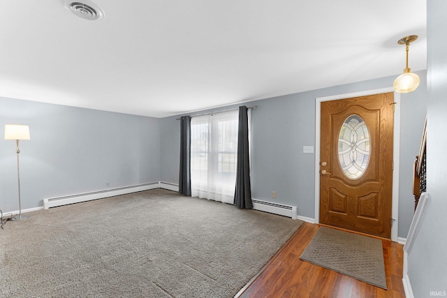 entrance foyer with a baseboard radiator, baseboards, visible vents, and wood finished floors