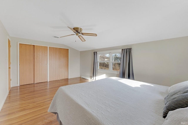 bedroom featuring baseboard heating, a ceiling fan, light wood-type flooring, and lofted ceiling