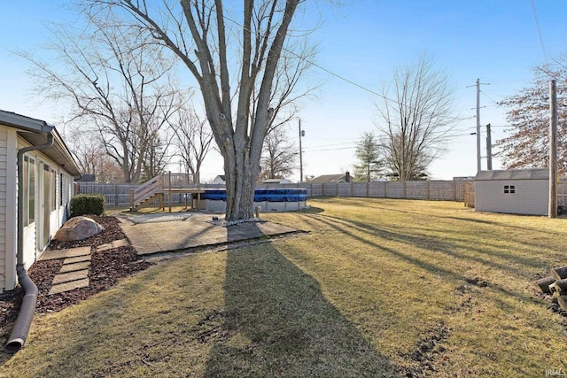 view of yard featuring a shed, a fenced in pool, an outdoor structure, and a fenced backyard