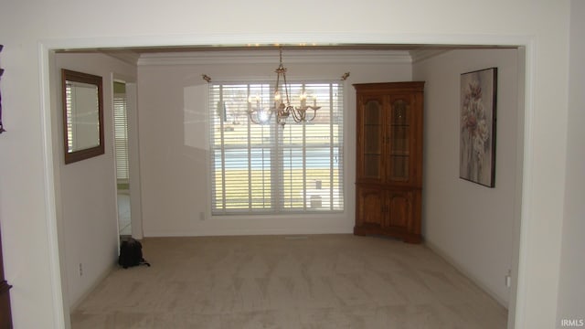 unfurnished dining area featuring crown molding, carpet, and an inviting chandelier