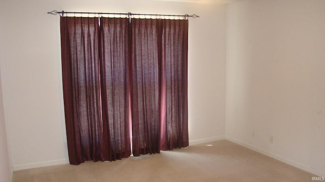 carpeted empty room with baseboards