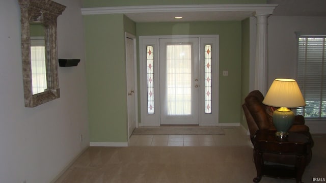 tiled foyer entrance featuring baseboards and carpet