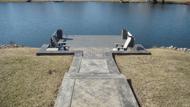 dock area featuring a lawn and a water view