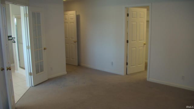 interior space featuring light colored carpet and baseboards