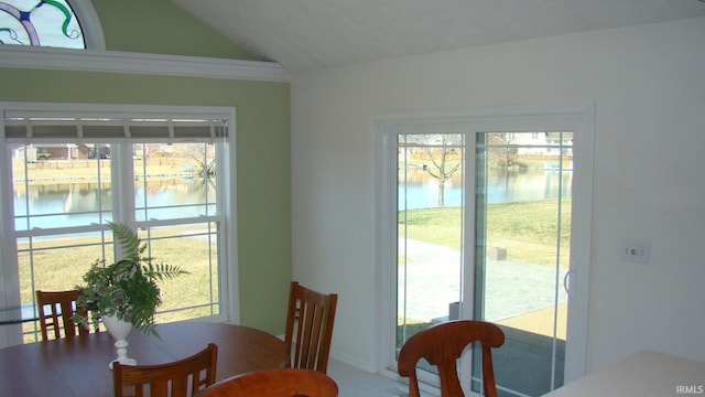 dining space featuring lofted ceiling and a water view