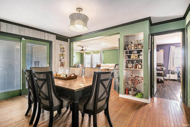 dining room with ceiling fan, plenty of natural light, ornamental molding, and hardwood / wood-style flooring