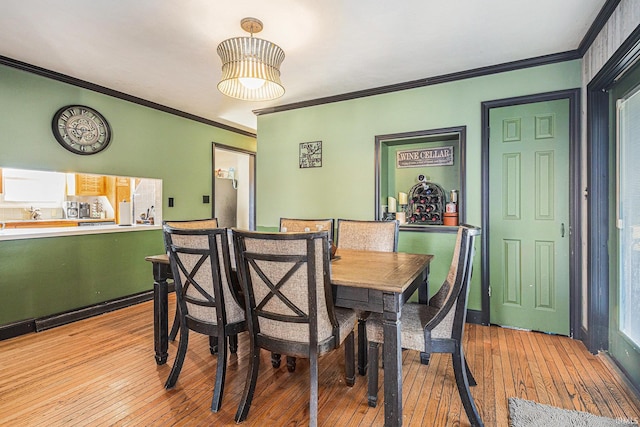 dining area with hardwood / wood-style floors and ornamental molding