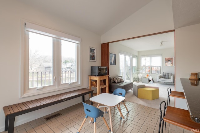 dining area with lofted ceiling and visible vents