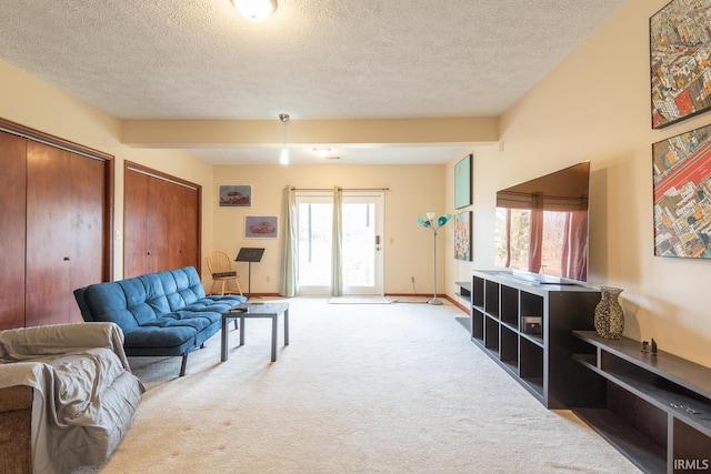 carpeted living room with a textured ceiling and baseboards