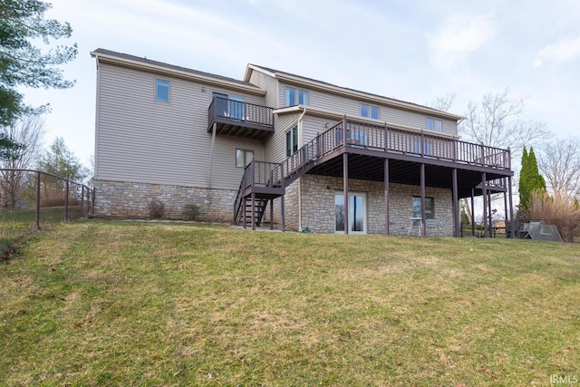 rear view of house featuring stairs, a yard, fence, and stone siding