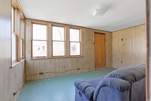 living room featuring wooden walls and concrete floors