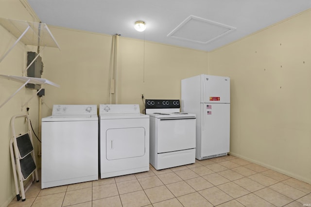 laundry area with light tile patterned floors, attic access, and washing machine and clothes dryer