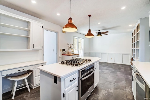 kitchen with open shelves, a center island, white cabinetry, appliances with stainless steel finishes, and wainscoting