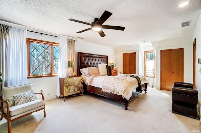 bedroom with visible vents, carpet flooring, and multiple windows