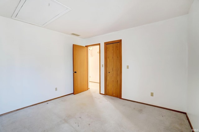 spare room with visible vents, baseboards, and light carpet