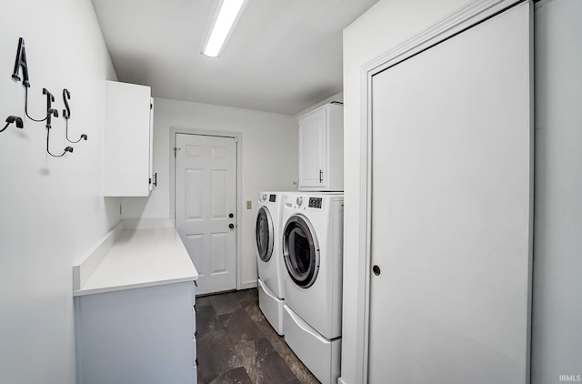 laundry room featuring washing machine and clothes dryer and cabinet space