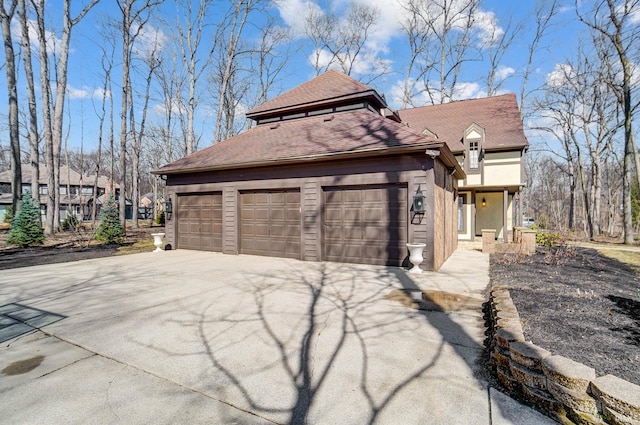 view of front of home with a garage, roof with shingles, driveway, and stucco siding