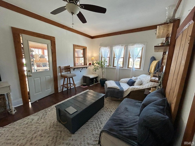 living area with baseboards, wood finished floors, and a ceiling fan