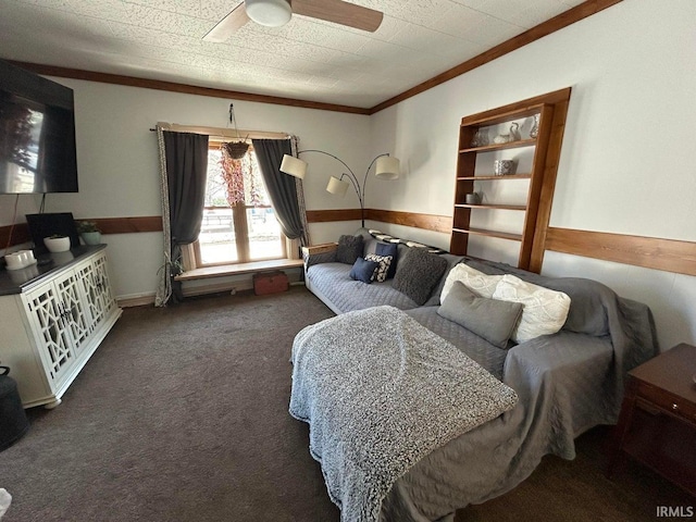 carpeted bedroom with a ceiling fan, wainscoting, and crown molding