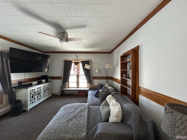 carpeted living area featuring ceiling fan, ornamental molding, and wainscoting