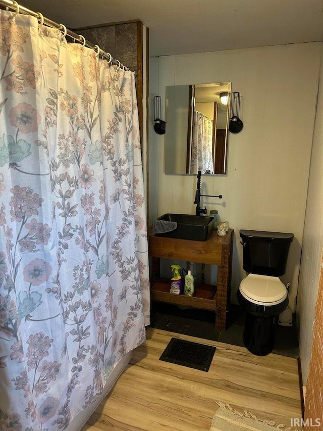 full bathroom featuring curtained shower, toilet, vanity, and wood finished floors