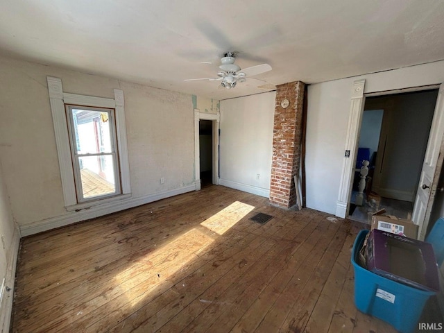 unfurnished bedroom featuring visible vents, baseboards, a ceiling fan, and hardwood / wood-style floors