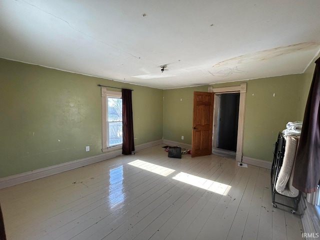 unfurnished bedroom with light wood-type flooring and baseboards