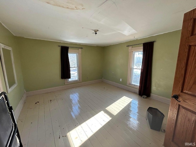 empty room with light wood-style floors and baseboards