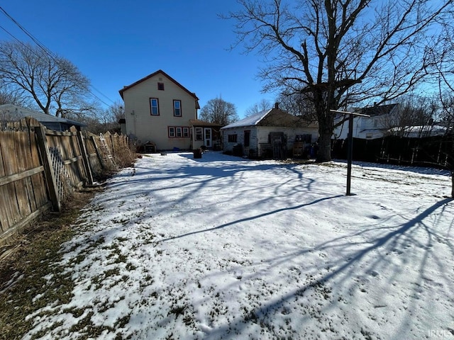 snow covered property featuring fence