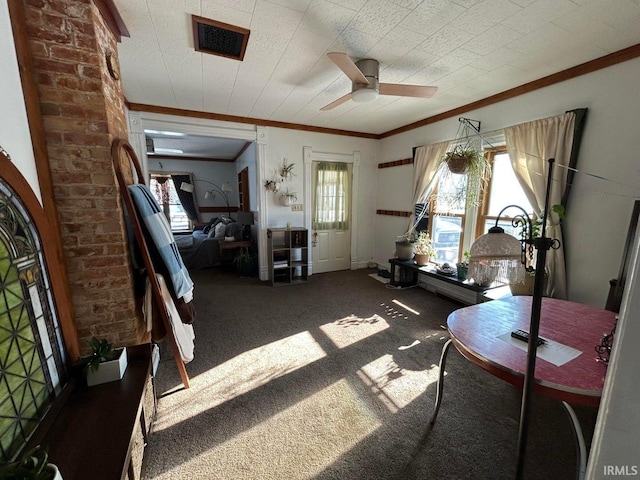 interior space with visible vents, ceiling fan, carpet flooring, and crown molding