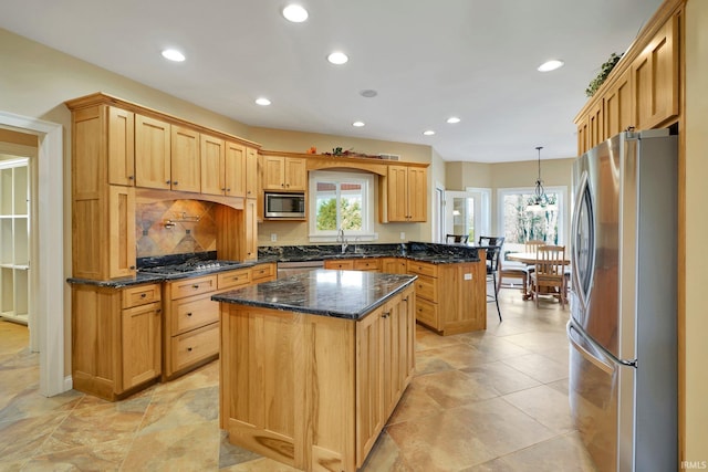 kitchen featuring a kitchen island, appliances with stainless steel finishes, a peninsula, plenty of natural light, and a sink