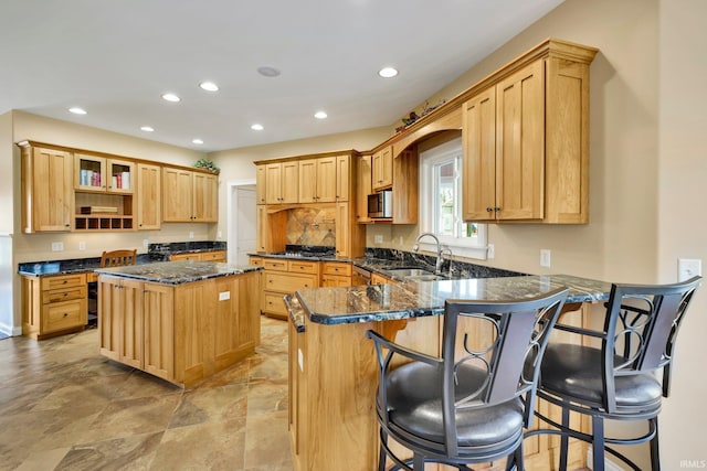 kitchen with a sink, open shelves, recessed lighting, dark stone counters, and a peninsula