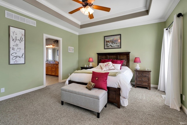 bedroom featuring a tray ceiling, ornamental molding, visible vents, and light carpet