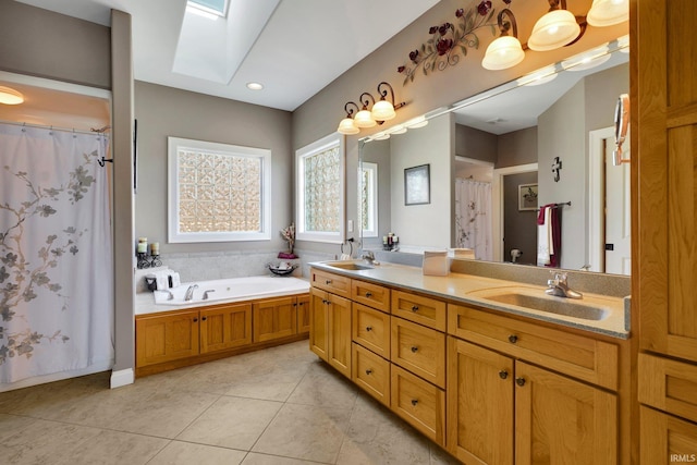 full bath with a sink, double vanity, a skylight, and tile patterned floors