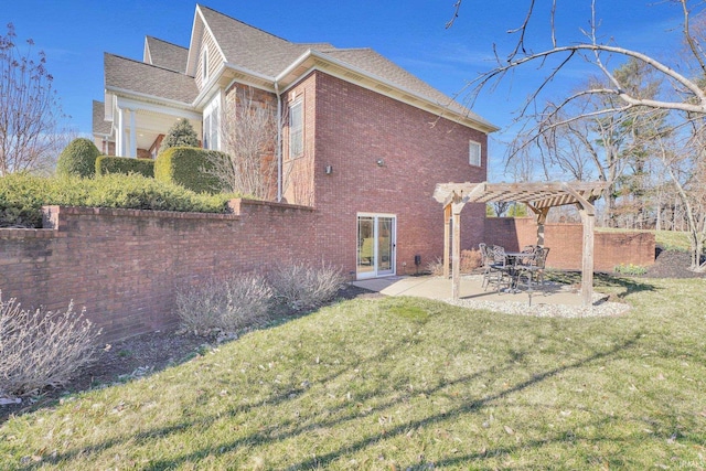 back of house featuring a yard, a patio, brick siding, and a pergola