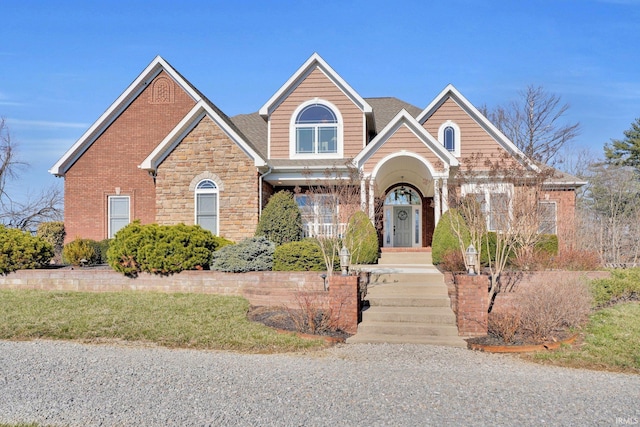 view of front of house featuring brick siding and a shingled roof