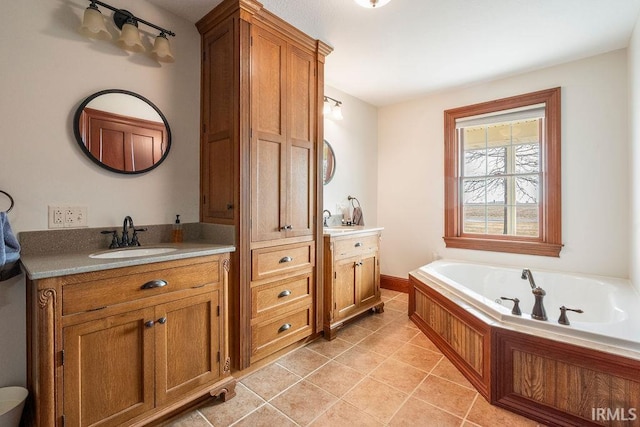 bathroom with a sink, two vanities, a bath, and tile patterned floors