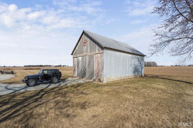 view of pole building with a rural view and a lawn