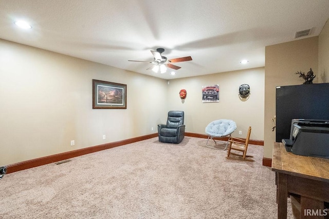 sitting room with visible vents, baseboards, carpet, and ceiling fan