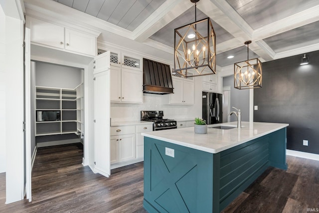 kitchen featuring black fridge, custom range hood, a sink, stainless steel range with gas cooktop, and an inviting chandelier