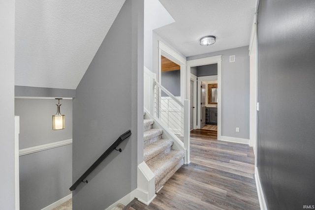 stairway featuring wood finished floors and baseboards