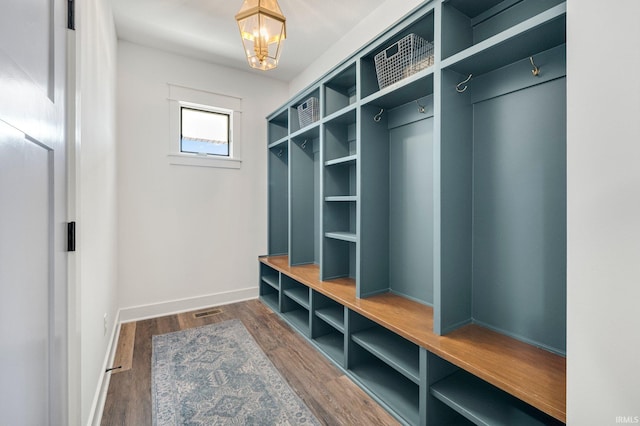 mudroom with an inviting chandelier, baseboards, and wood finished floors