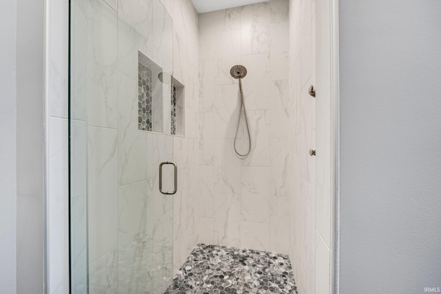 bathroom featuring a marble finish shower