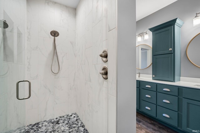 bathroom with vanity, wood finished floors, and a shower stall