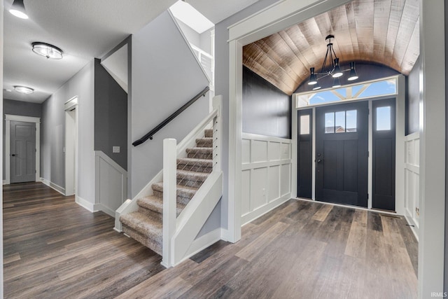 entryway featuring lofted ceiling, stairway, wood finished floors, and baseboards