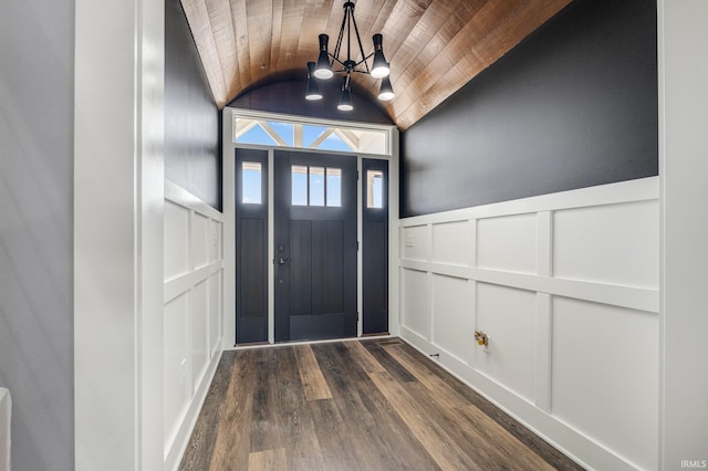 foyer entrance with dark wood finished floors, an inviting chandelier, wooden ceiling, wainscoting, and lofted ceiling